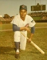 Major League baseball player Brock Davis in Cubs uniform, kneeling at Wrigley Field, with bat.